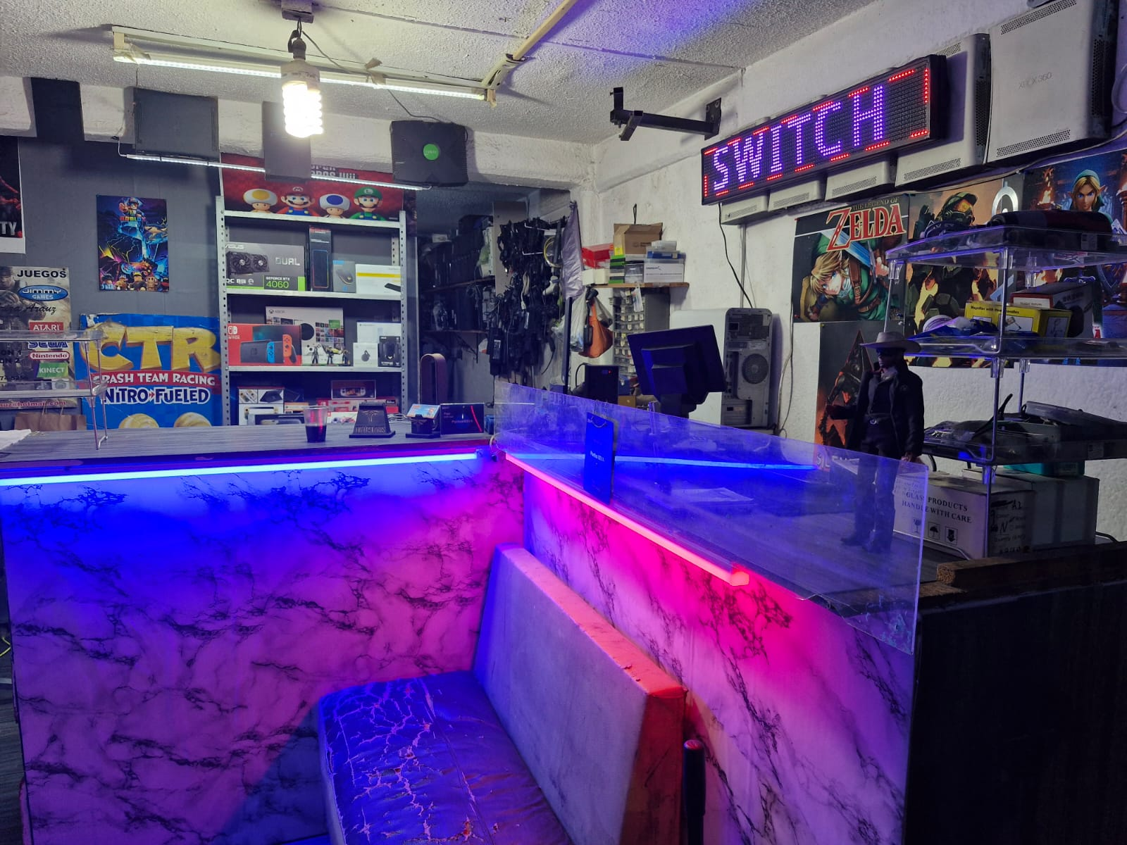 Interior del local Jimmy Games en Coacalco, con mostradores iluminados y productos de computación y videojuegos